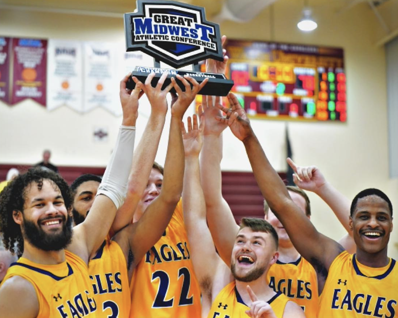 The Eagles collectively hold the Great Midwest Athletic Conference trophy over their heads.
