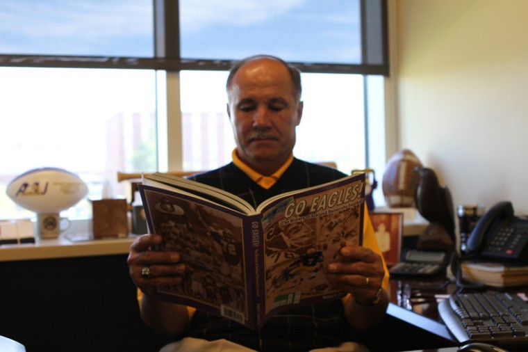 Ralph+Tomassi+reads+the+book+he+wrote+about+Ashland+football.+Tomassi+is+retiring+in+October.%C2%A0