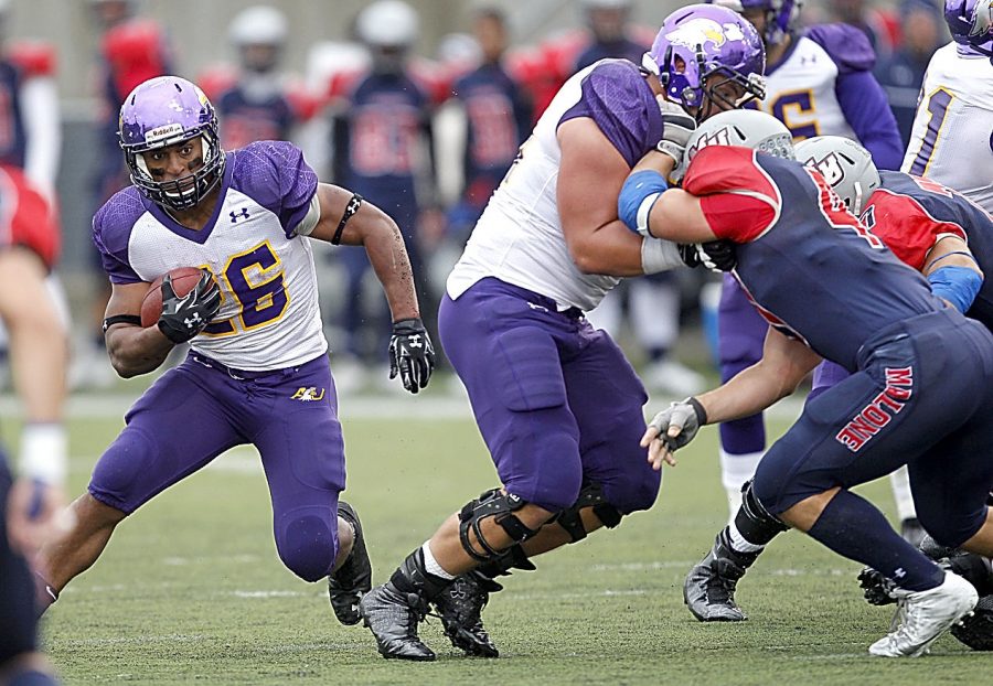 Ashland University's Vance Settlemire (26) runs behind the blocking of Zachary Douglass (65) on Malone University's Ryan Weber (47) during college football action Saturday, Oct. 3, 2015 at Tom Benson Hall of Fame Stadium in Canton. AU won the game 42-17.