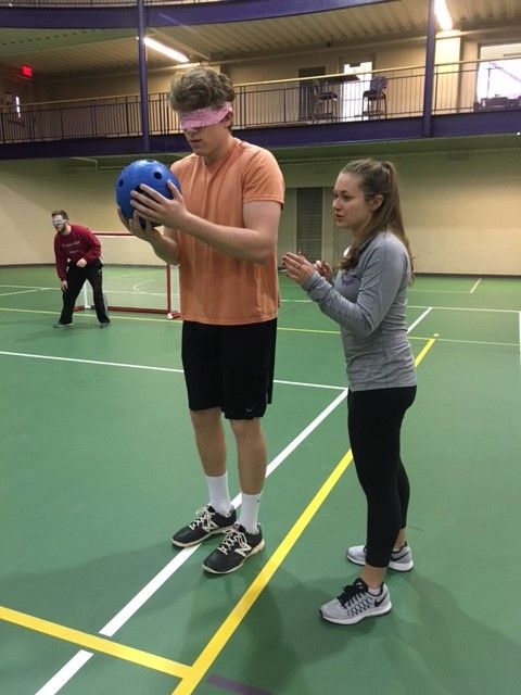 Courtney Troyer helps Corbon Angermeier during the Goal Ball Tournament.