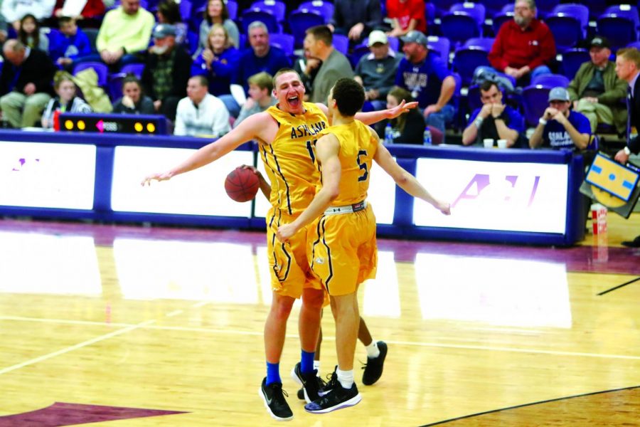 Teammates Drew Noble (left) and Aaron Thompson (right) celebrate in the air with a chest bump during a game earlier this season in Kates Gymnasium.