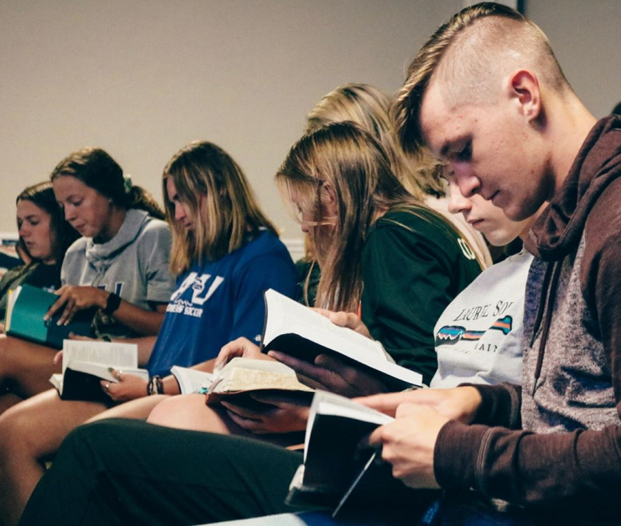 Students+at+an+FCA+meeting+following+along+in+their+bibles.