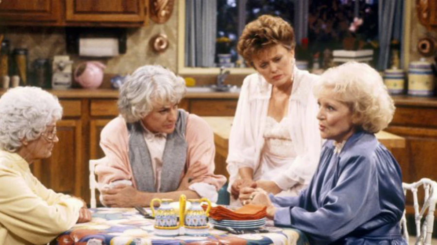 The Golden Girls crowd around their nightly cheesecake while listening to one of Roses stories