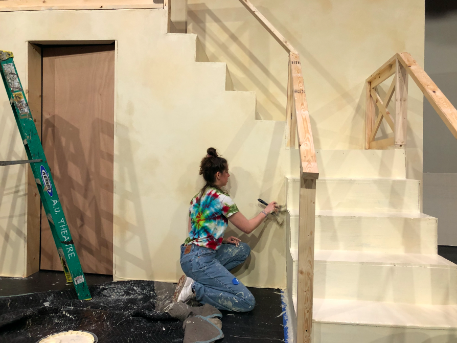 A member of the crew for Mamma Mia! painting a set piece.