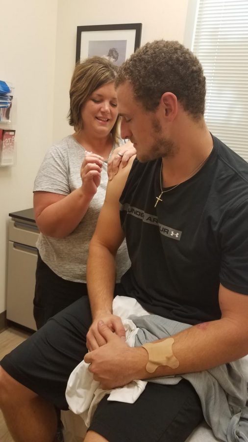 Ashland University Student Health Center Nurse Patty Owens gives a flu shot to a student.