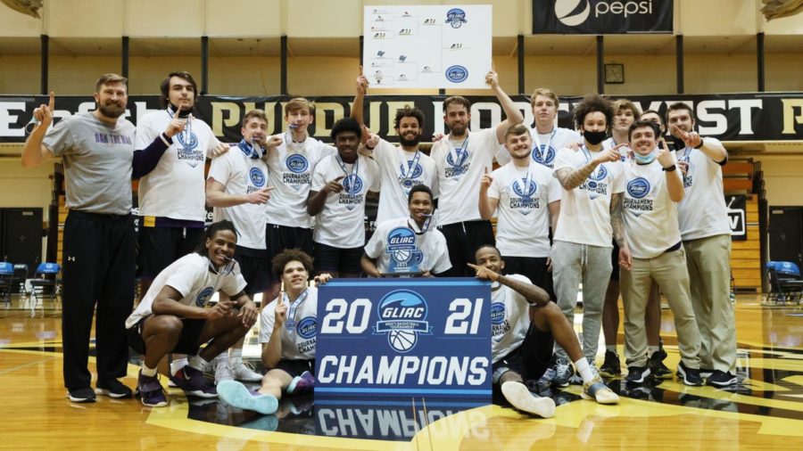 Mens basketball team poses for photo after winning the GLIAC title.