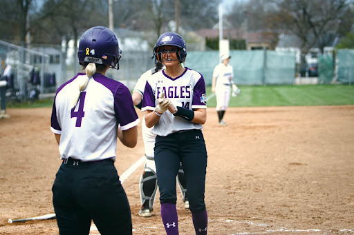Jordyn Severns and Kaitlyn Carney celebrate scoring runs for their team putting Ashland up 2-1 in the third inning. 