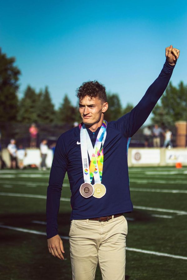 Trevor Bassitt stands infront of the Eagle faithful in the opening football game of the 2022 season. Bassitt stands with a silver and bronze medal around his neck. 