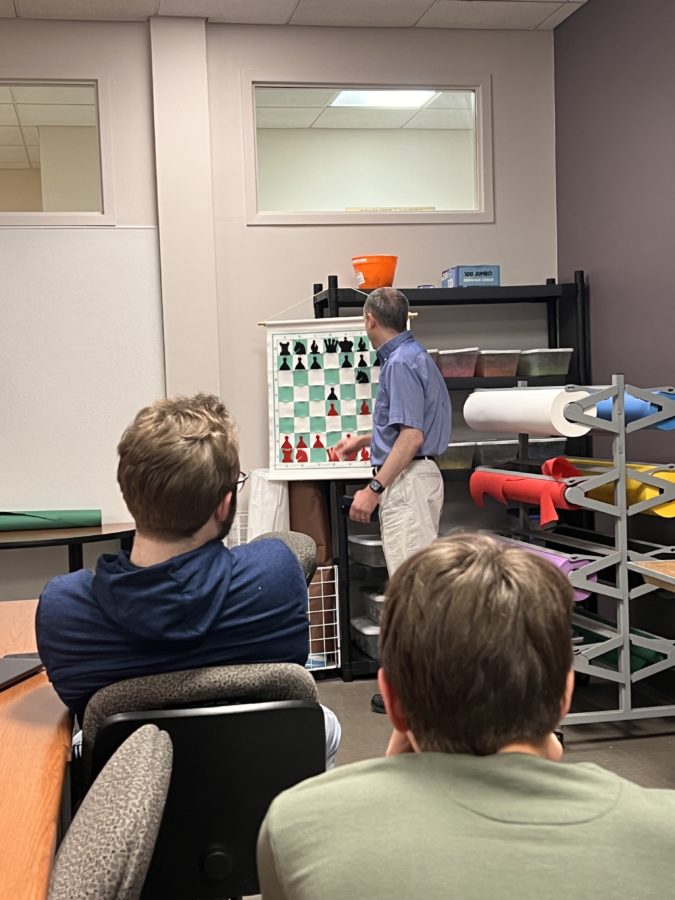 Dennis Monokroussos showing certain chess moves to his club members in the source room of the student center.