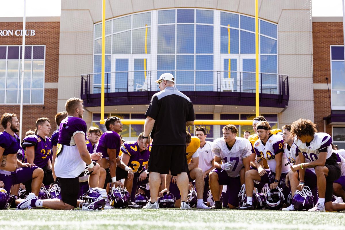 Head Coach Doug Geiser talks with his team after a practice in the preseason training camp.