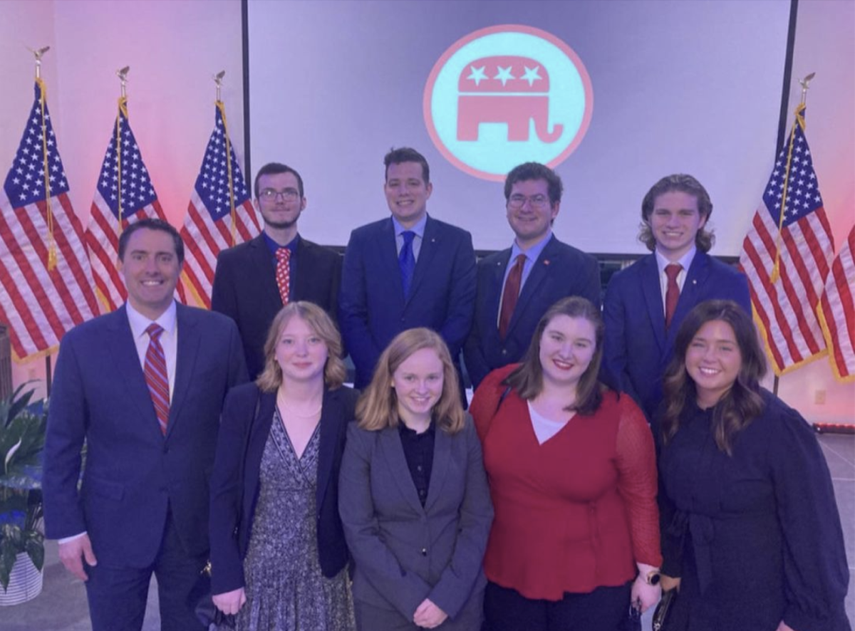 The+College+Republicans+stand+for+a+picture+in+front+of+the+organizations+logo.