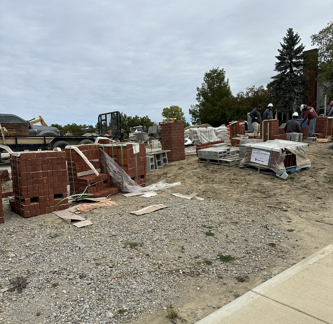 Construction workers continue to build the brick wall in front of the new Parking Lot I.