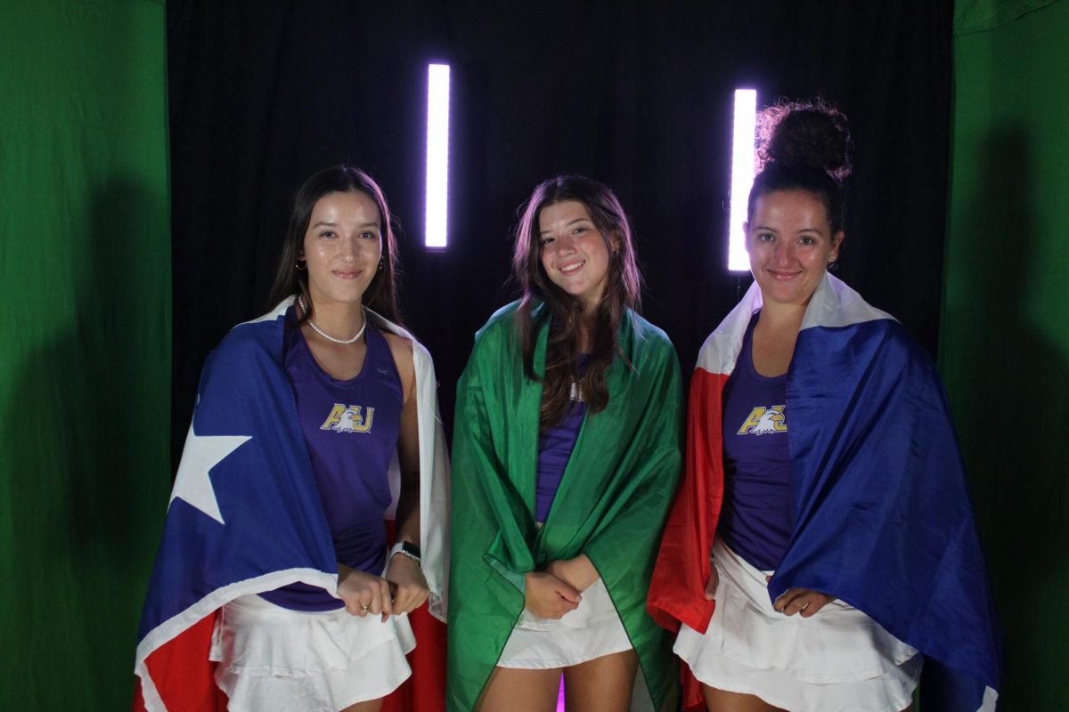 Eagle international womens tennis players stand together with their respective national flags.