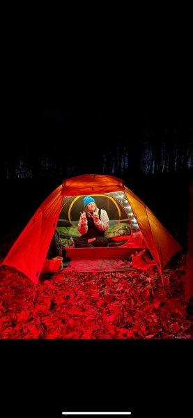 Brynn camping in the woods late at night.