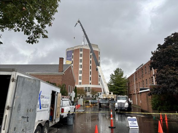 Crane lifts one of the antennas to the library rooftop. 