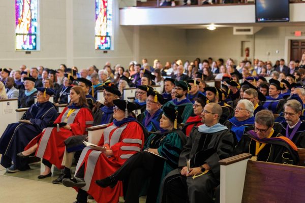 Faculty in academic regalia, watching Peede’s inauguration.