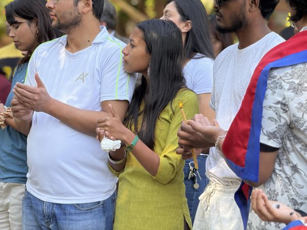 Students from Nepal hold candles during a campus vigil. 