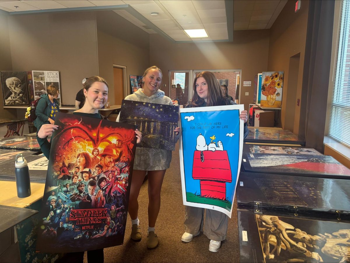 Ashland University students showcasing some of the posters that were offered: popular television shows, art, and comedy. 