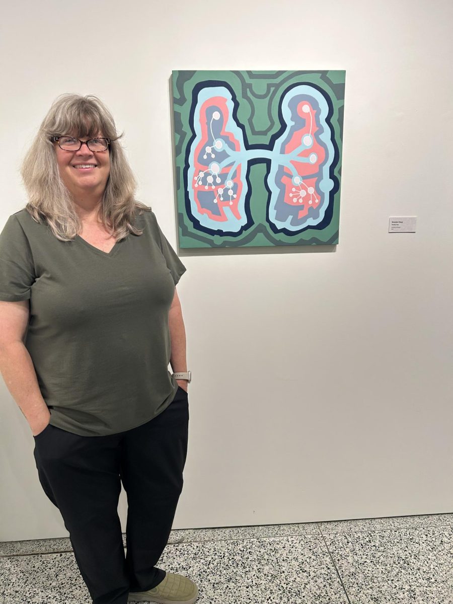 Cynthia Petry next to “Family Tree” by Alumni Brandon Doup.