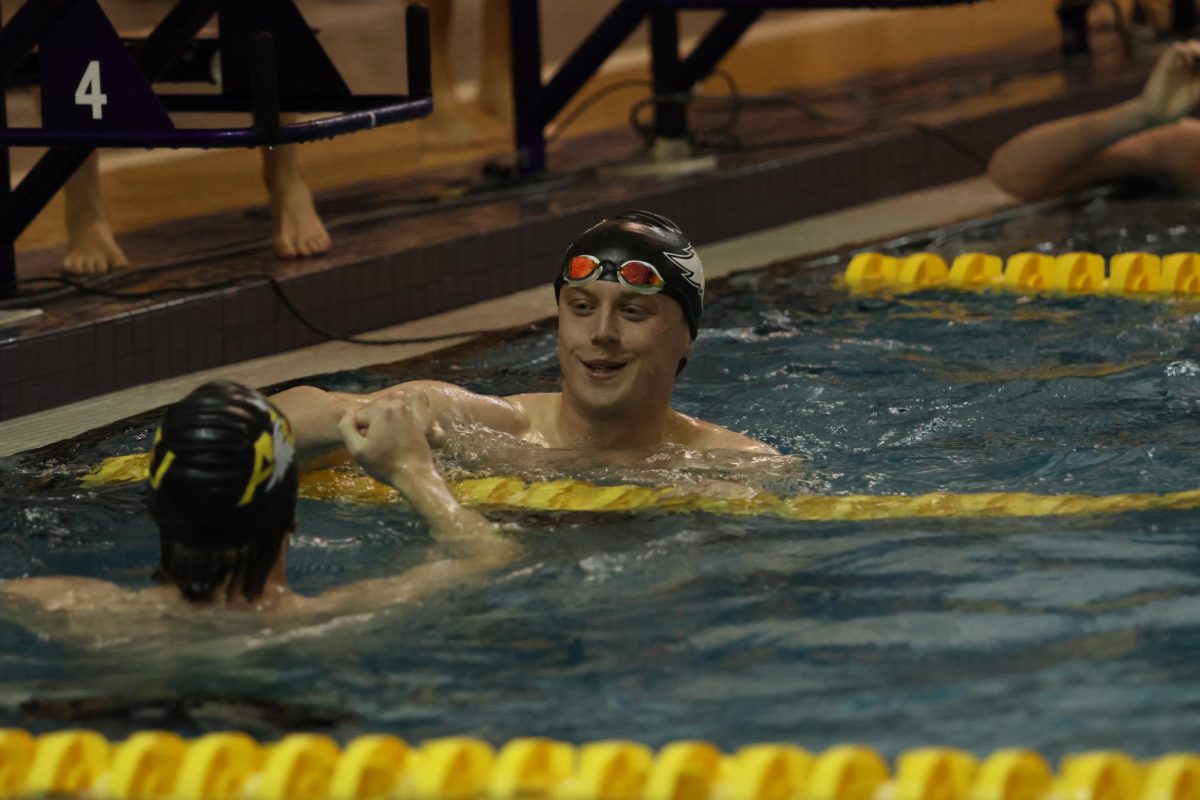 Senior Robin Falk high fives teammate Nick Girz after a race.