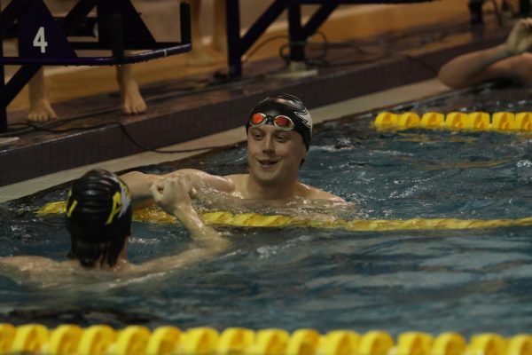 Senior Robin Falk high fives teammate Nick Girz after a race.