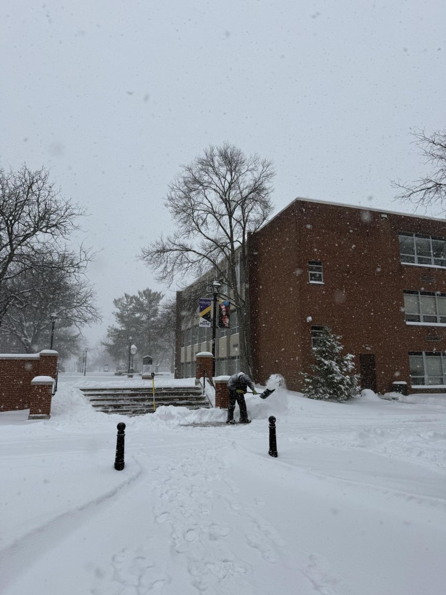 A facility worker shovels snow off the stairs on the main campus the morning of Jan. 25.
