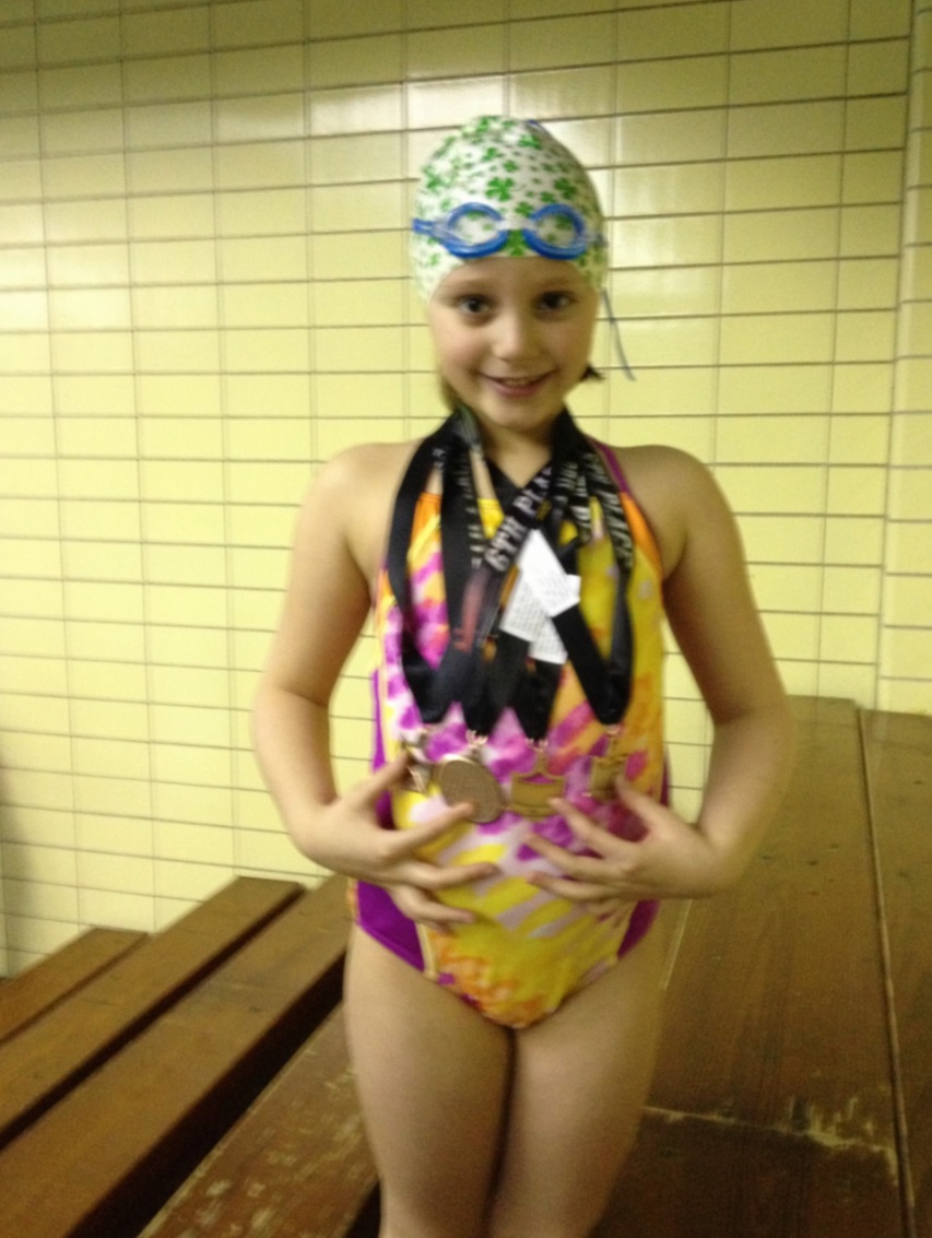 O’Toole, 7, proudly shows off her medals at swim practice.